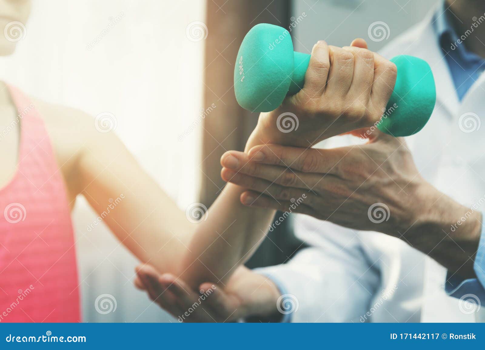 physiotherapy - physiotherapist help woman patient to recover from hand injury. dumbbell exercises