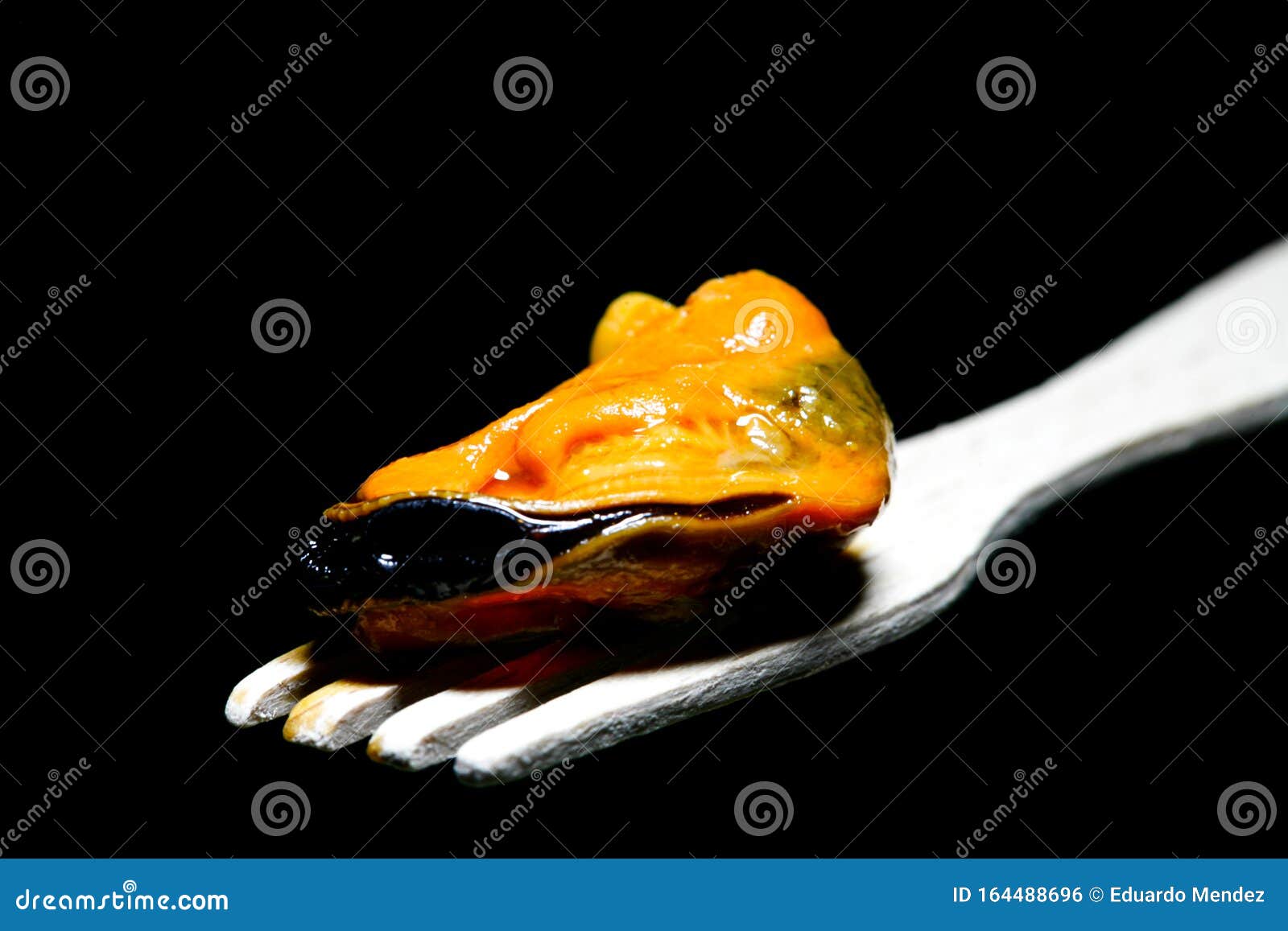 pickled mussel on a wooden fork