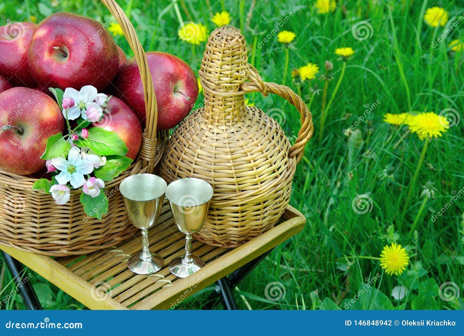 Picnic on the Grass. Red Apples in a Wicker Basket and a Bottle of Wine ...