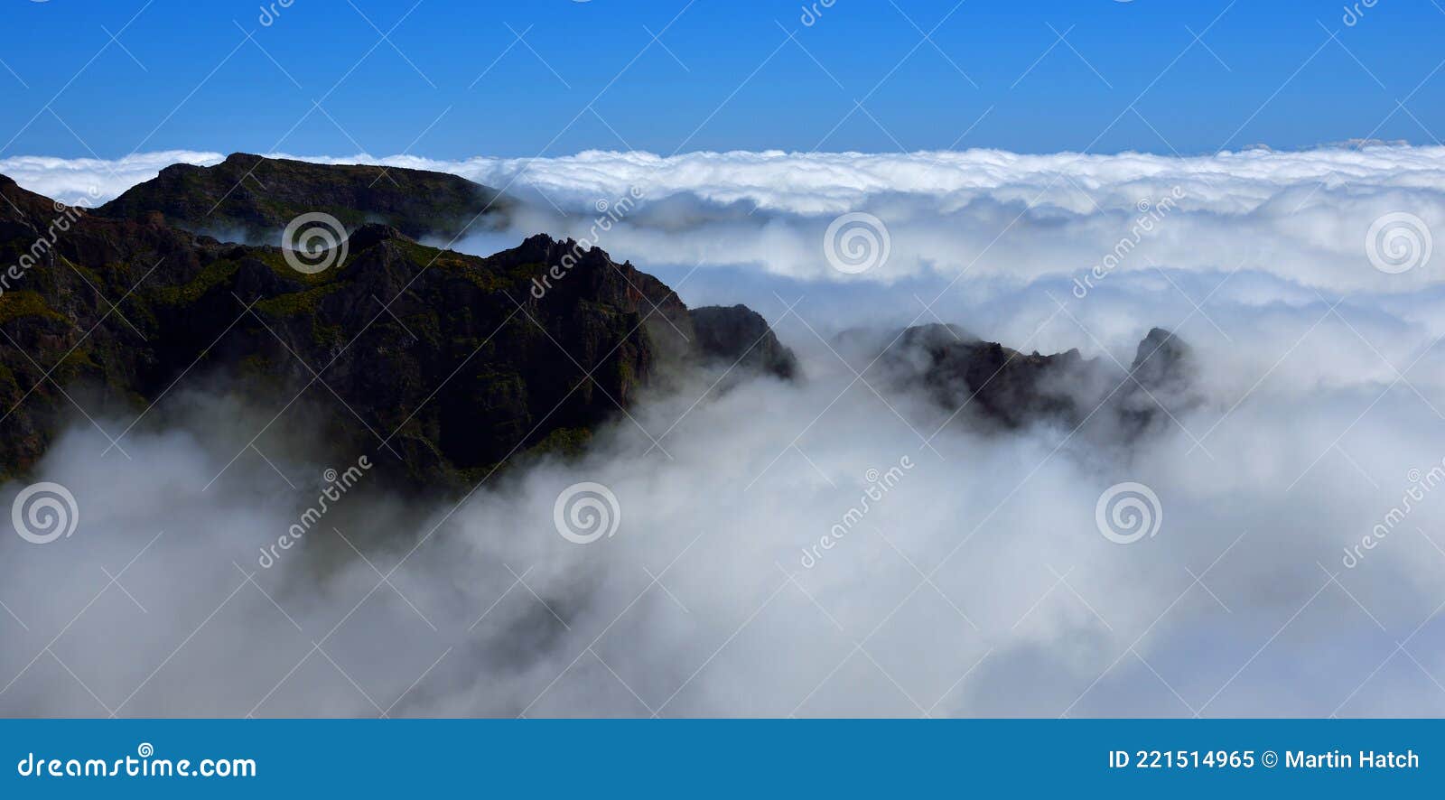 pico do areeiro madeira peaks above the clouds with blue sky above.