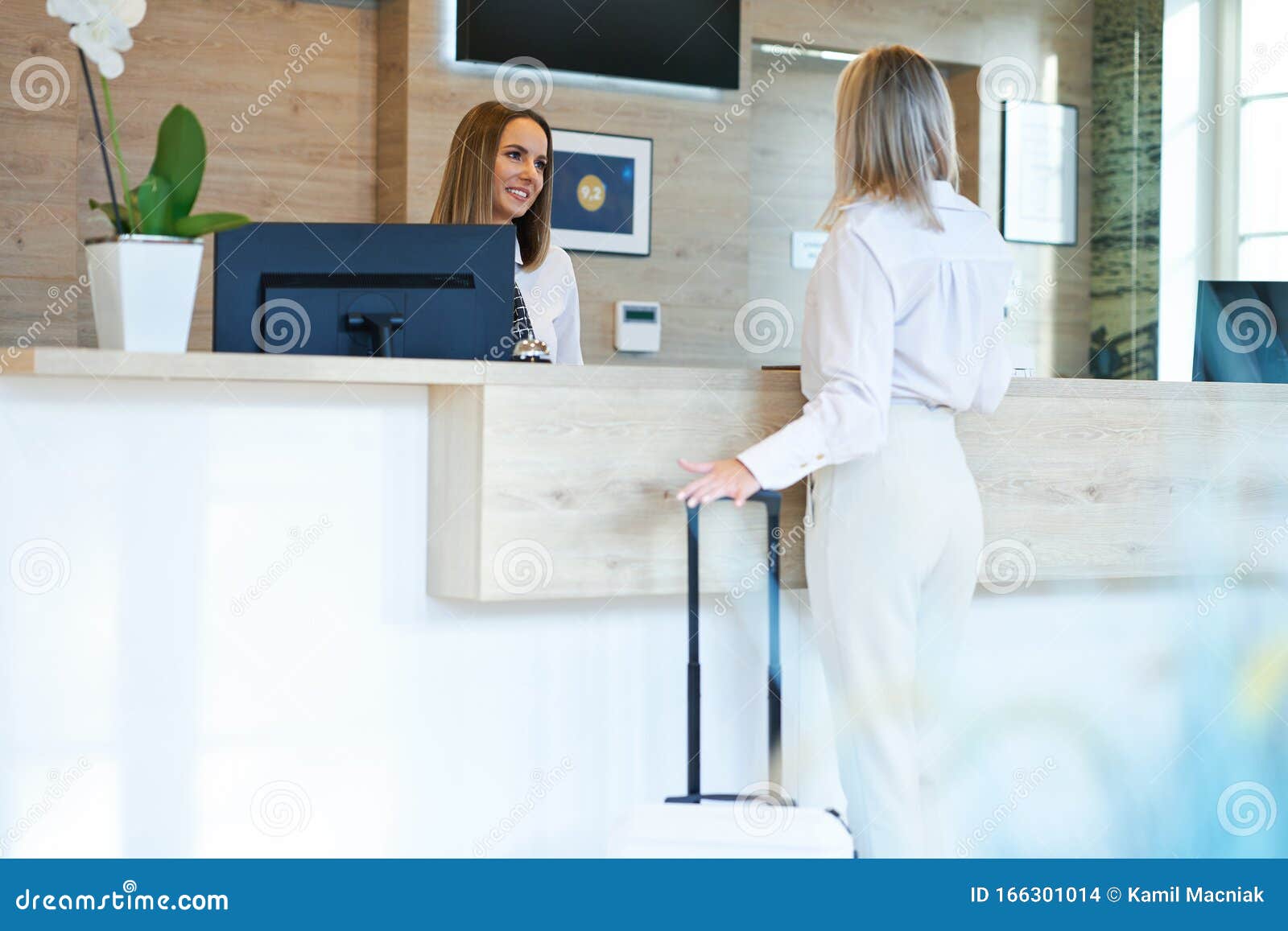 Receptionist And Businesswoman At Hotel Front Desk Stock Photo