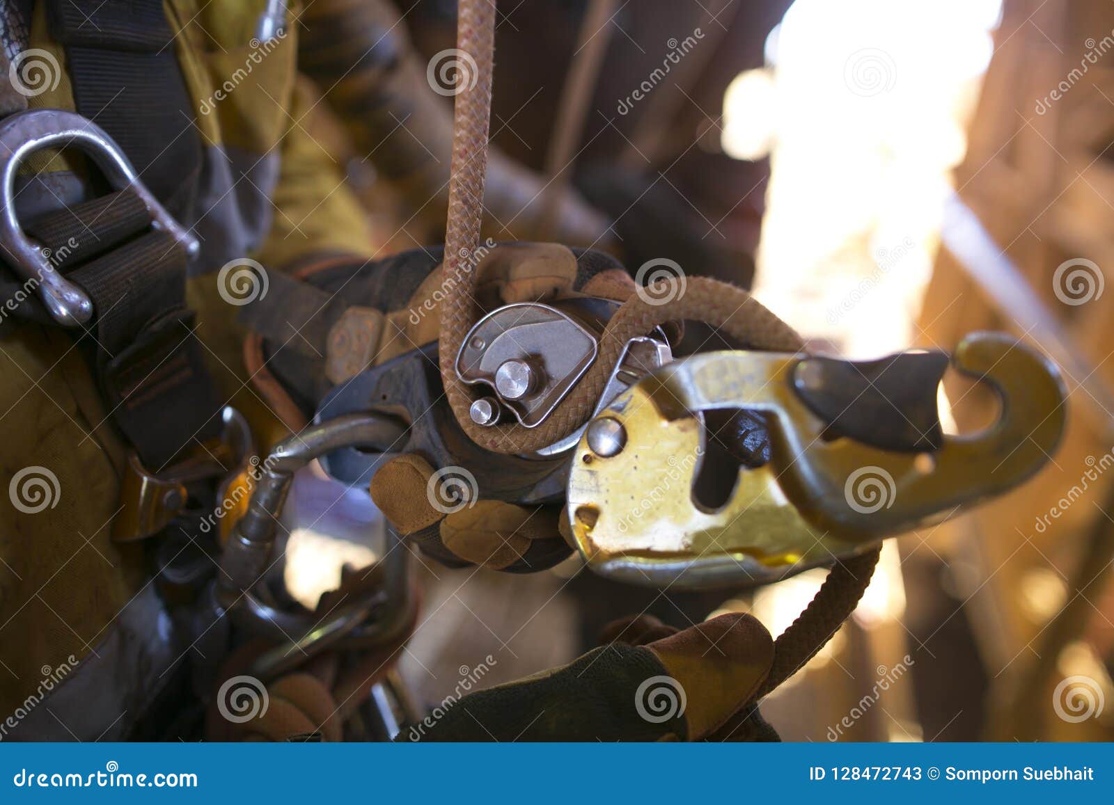 picture of rope access male hand opening descender and clipping connecting inserting with 10 mm low stretch nylon abseiling rope