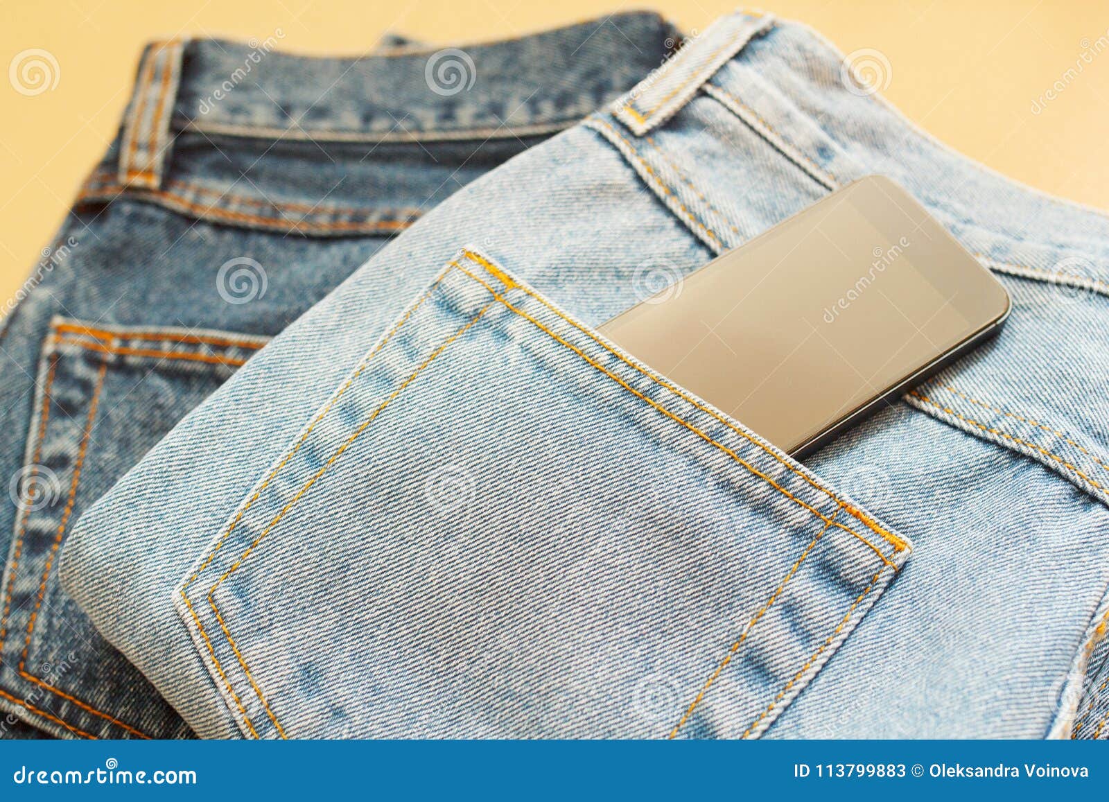 Picture of Two Jeans with Mobile in Pocket on Craft Wooden Background ...