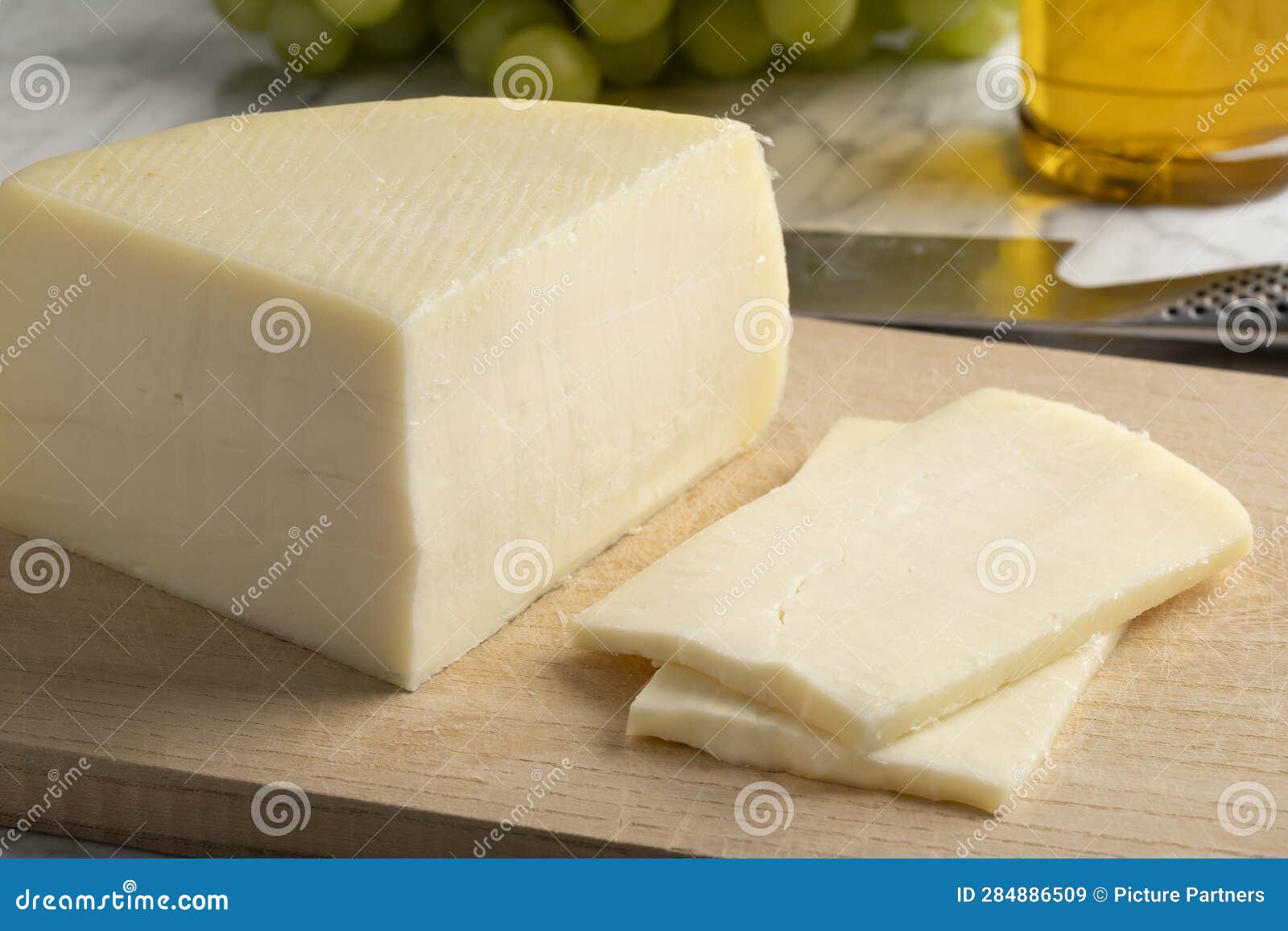 piece of artisanal semi soft italian bel paese cheese and slices