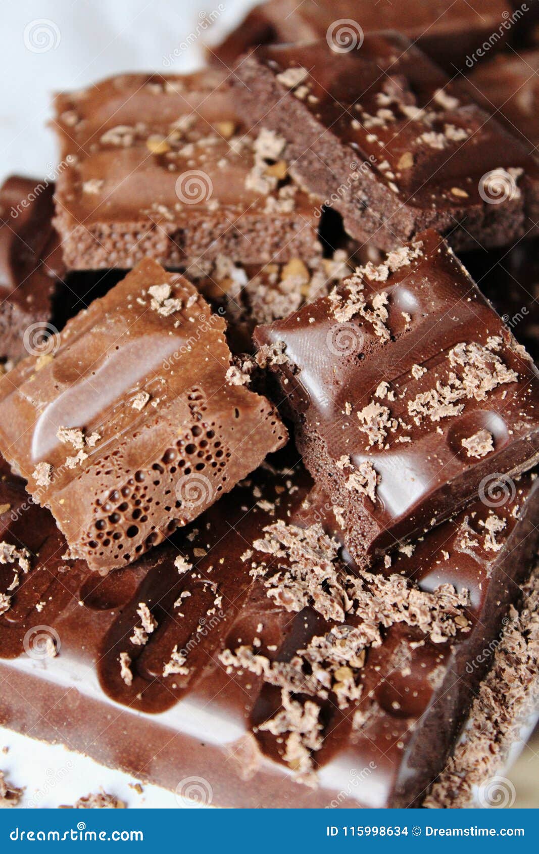 pieces of broken brow chocolate sprinkled with grated chocolate closeup.
