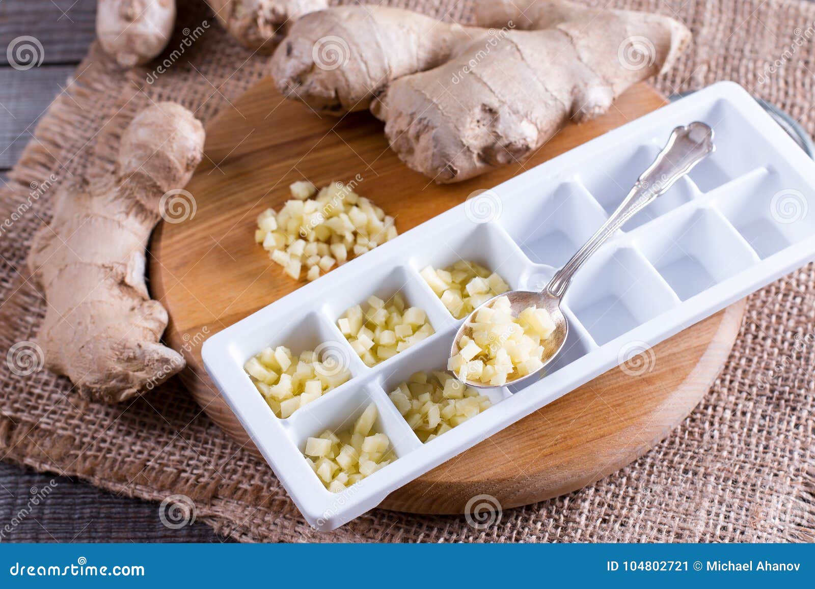 Pieces of Ginger in a Container for Freezing Ice Cubes on a Board Stock