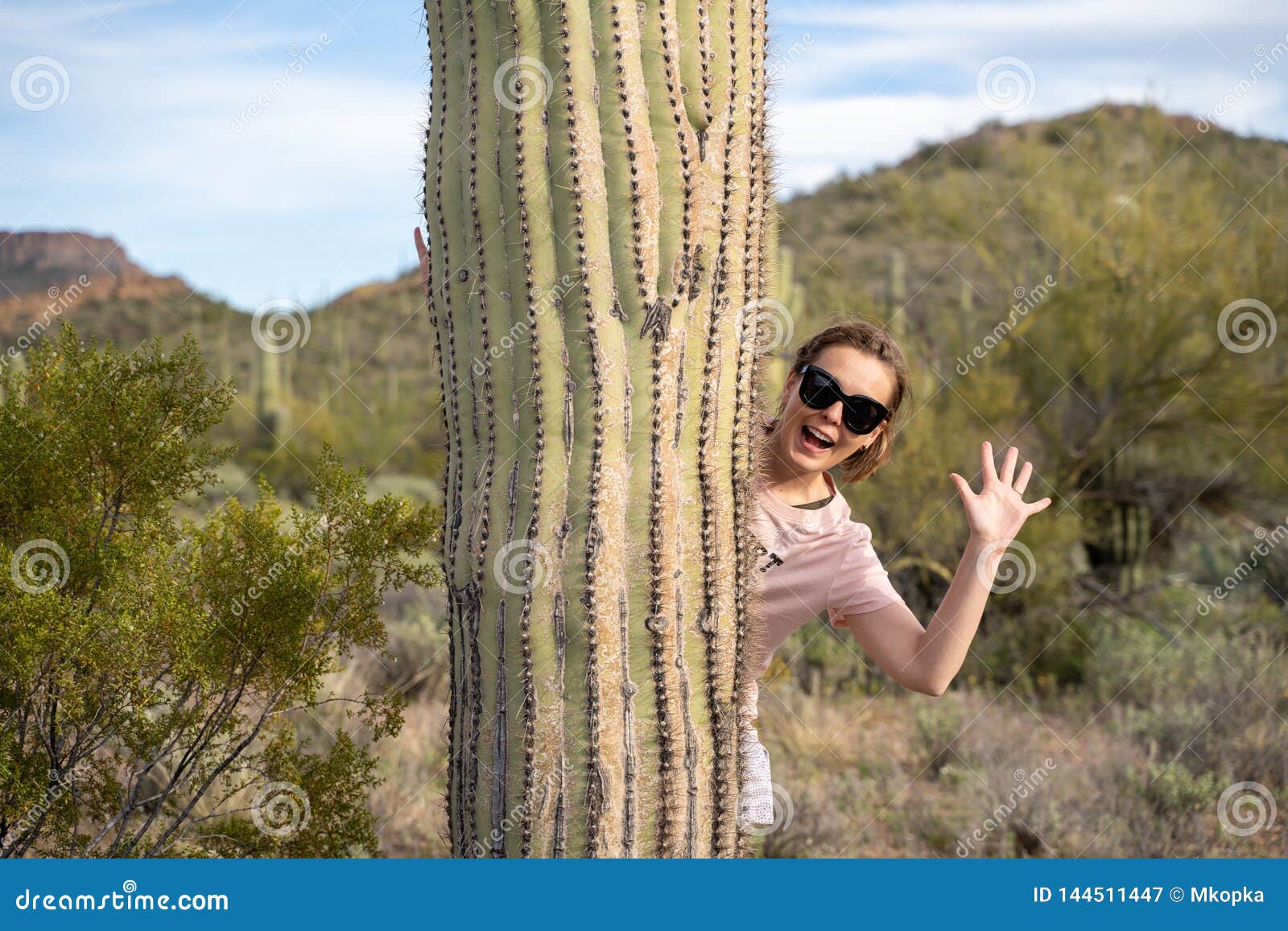 Pieles Y Ondas De La Mujer Adulta Mientras Que Se Coloca Detrás De Un  Cactus Grande Del Saguaro En El Desierto De Sonoran Imagen de archivo -  Imagen de conducir, nubes: 144511447