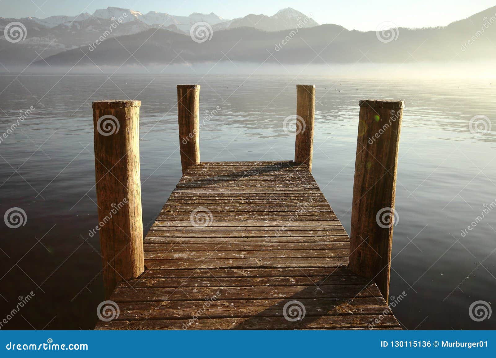 a pier with mountains and a lake