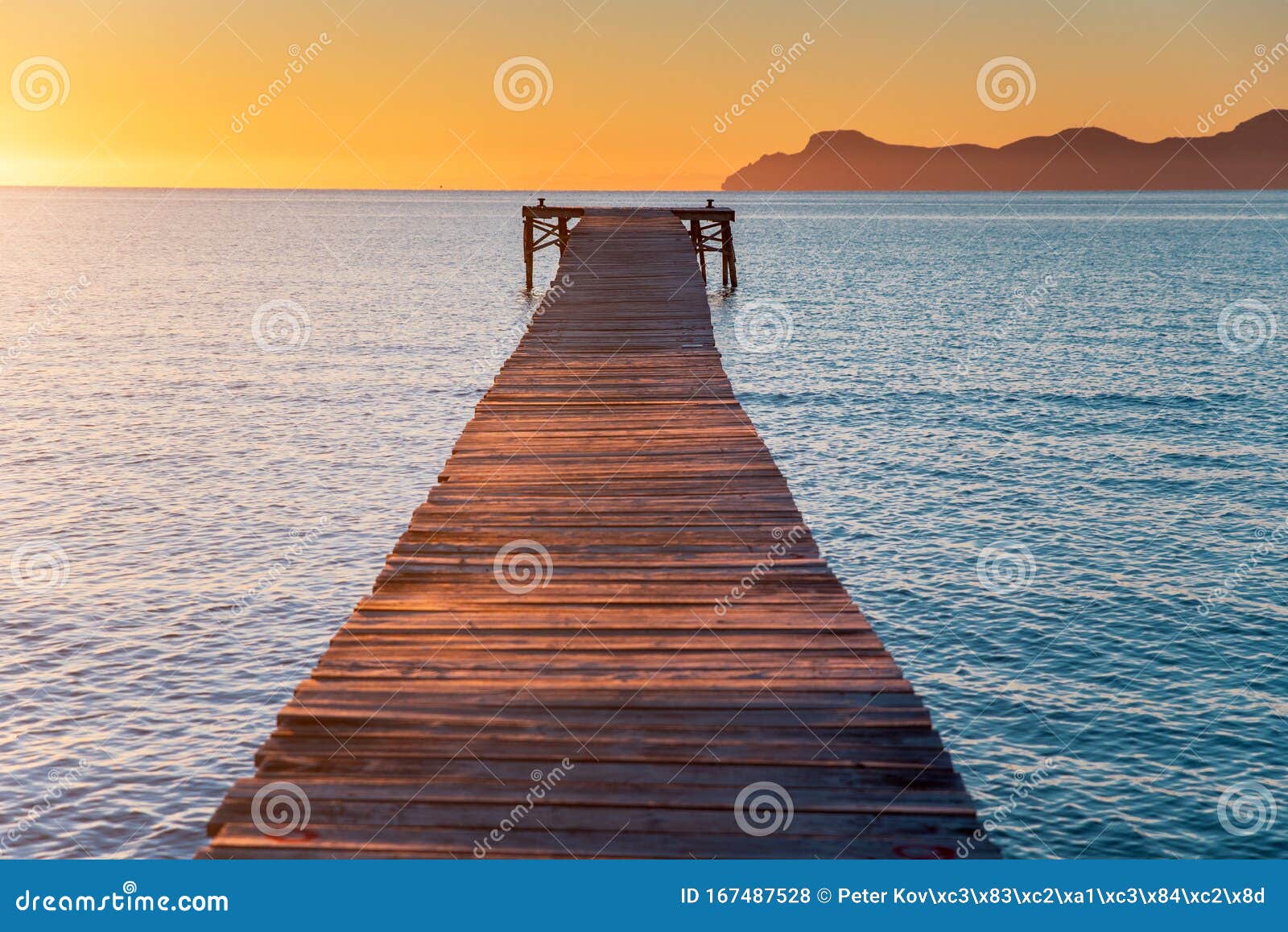 pier in orange sunrise colors. playa de muro