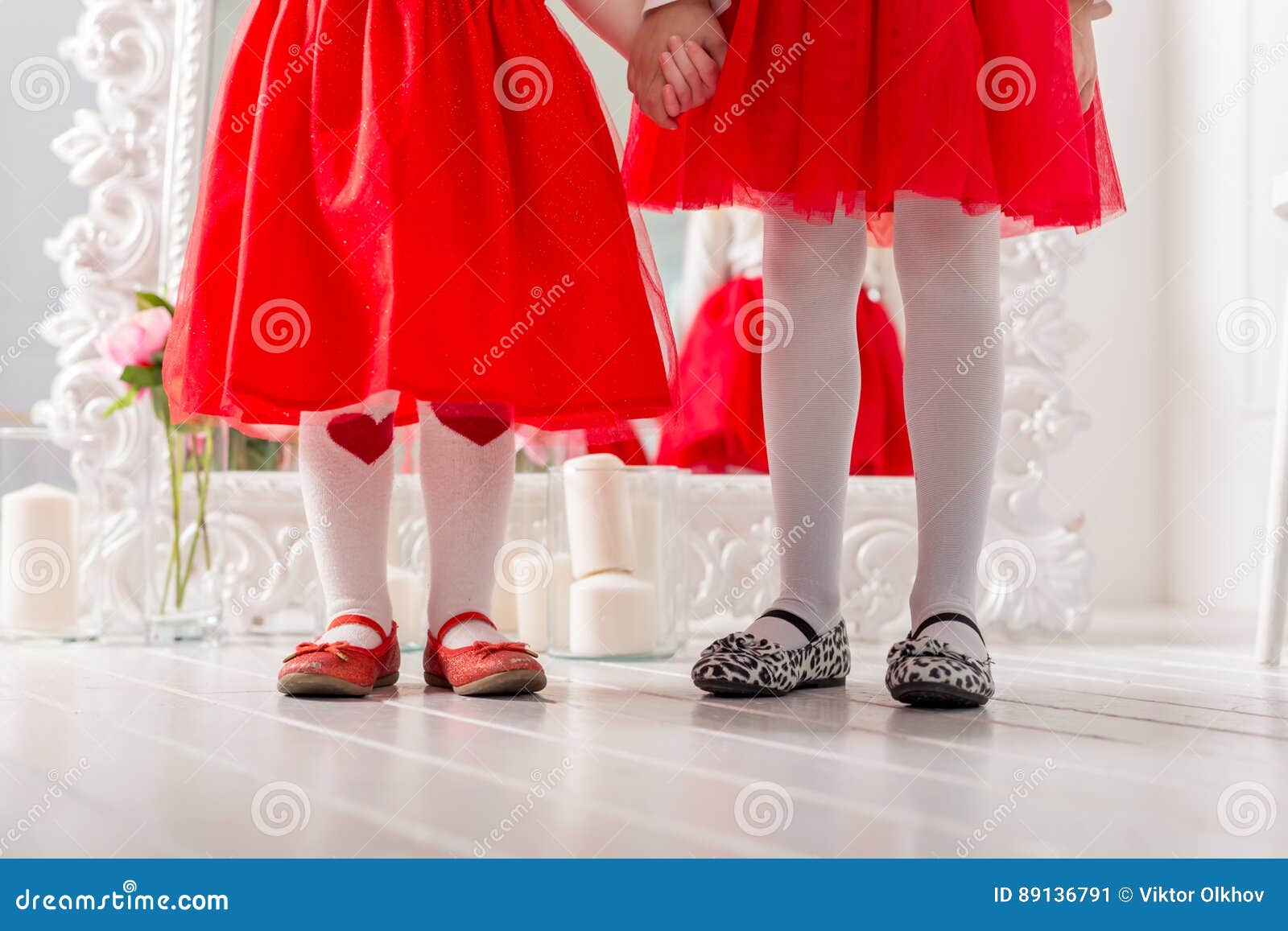 Piernas En Zapatos Dos Niñas En Vestidos Rojos Imagen de archivo - Imagen de junto, adulto: