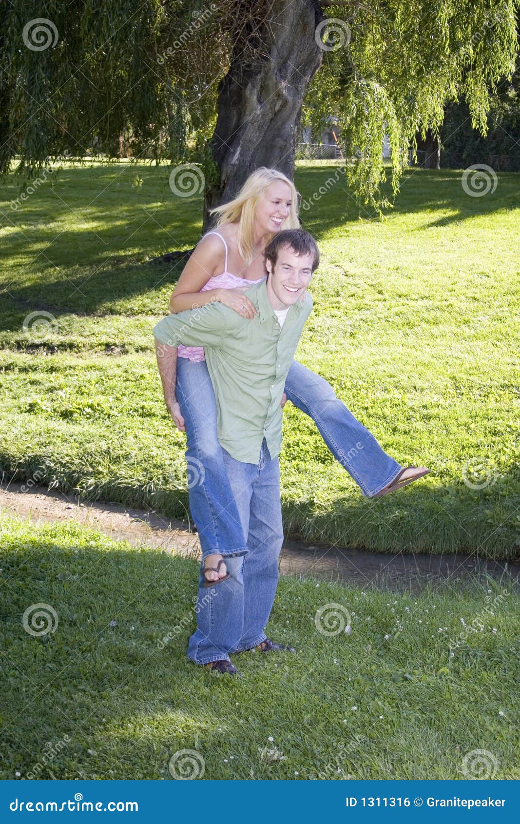 Couple playing piggyback ride in park Stock Photo - Alamy