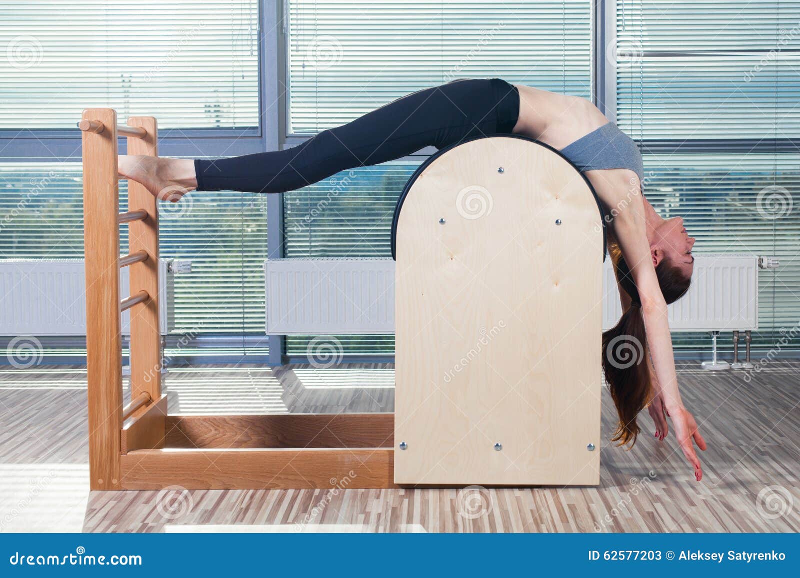 Pilates trainer exercises on a pilates barrel. Body training