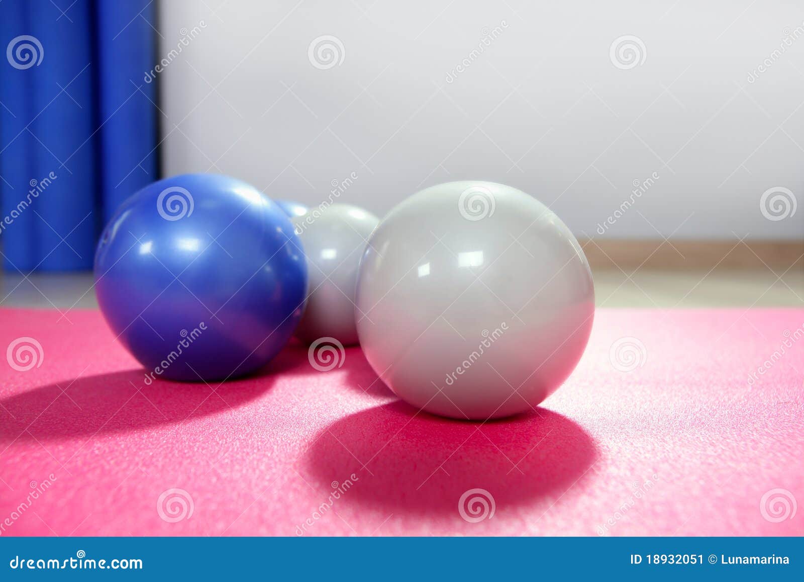 pilates toning balls over red yoga mat