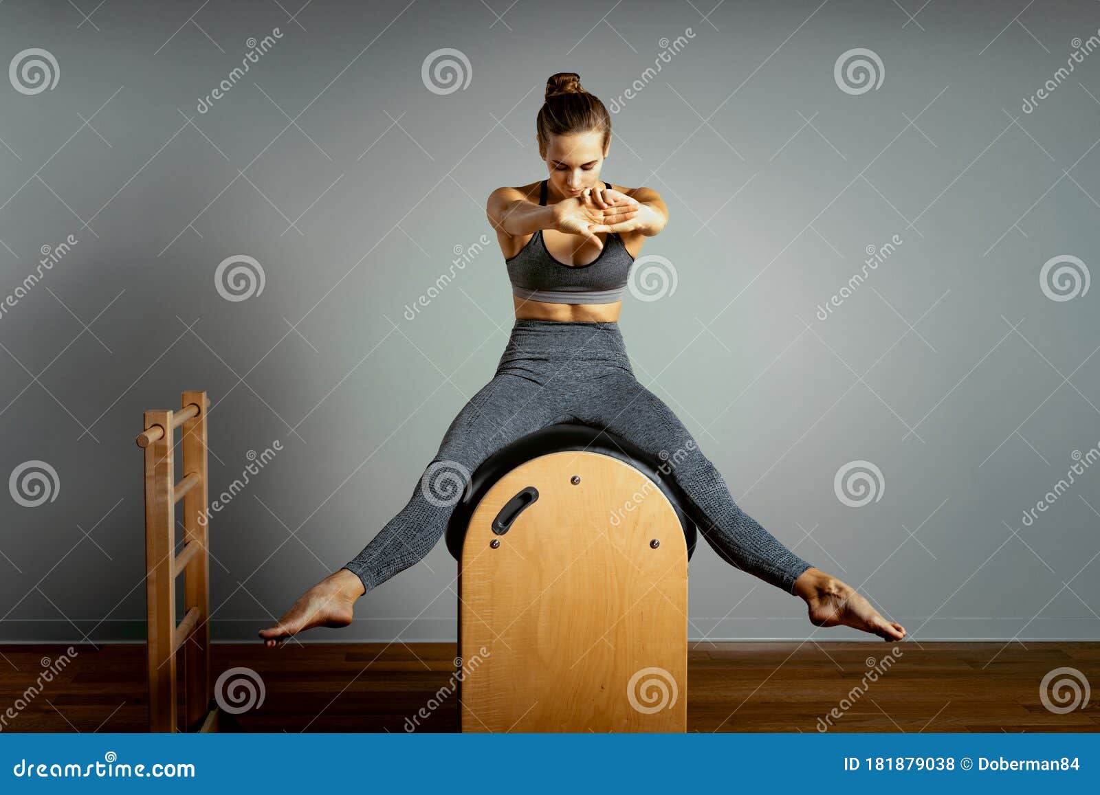 Pilates trainer exercises on a pilates barrel. Body training