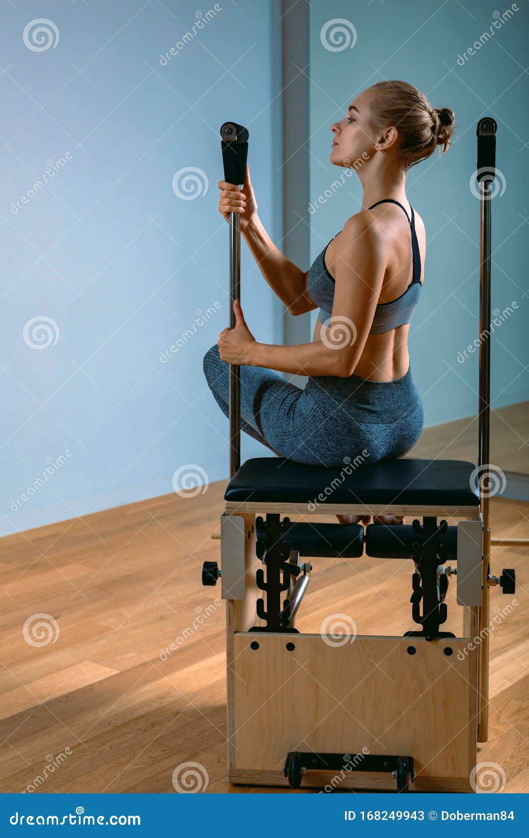 Pilates Woman in a Reformer Doing Stretching Exercises in the Gym ...