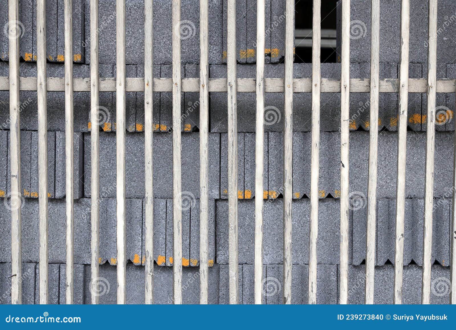 pile of concrete block behind old scantling wood fence, texture background