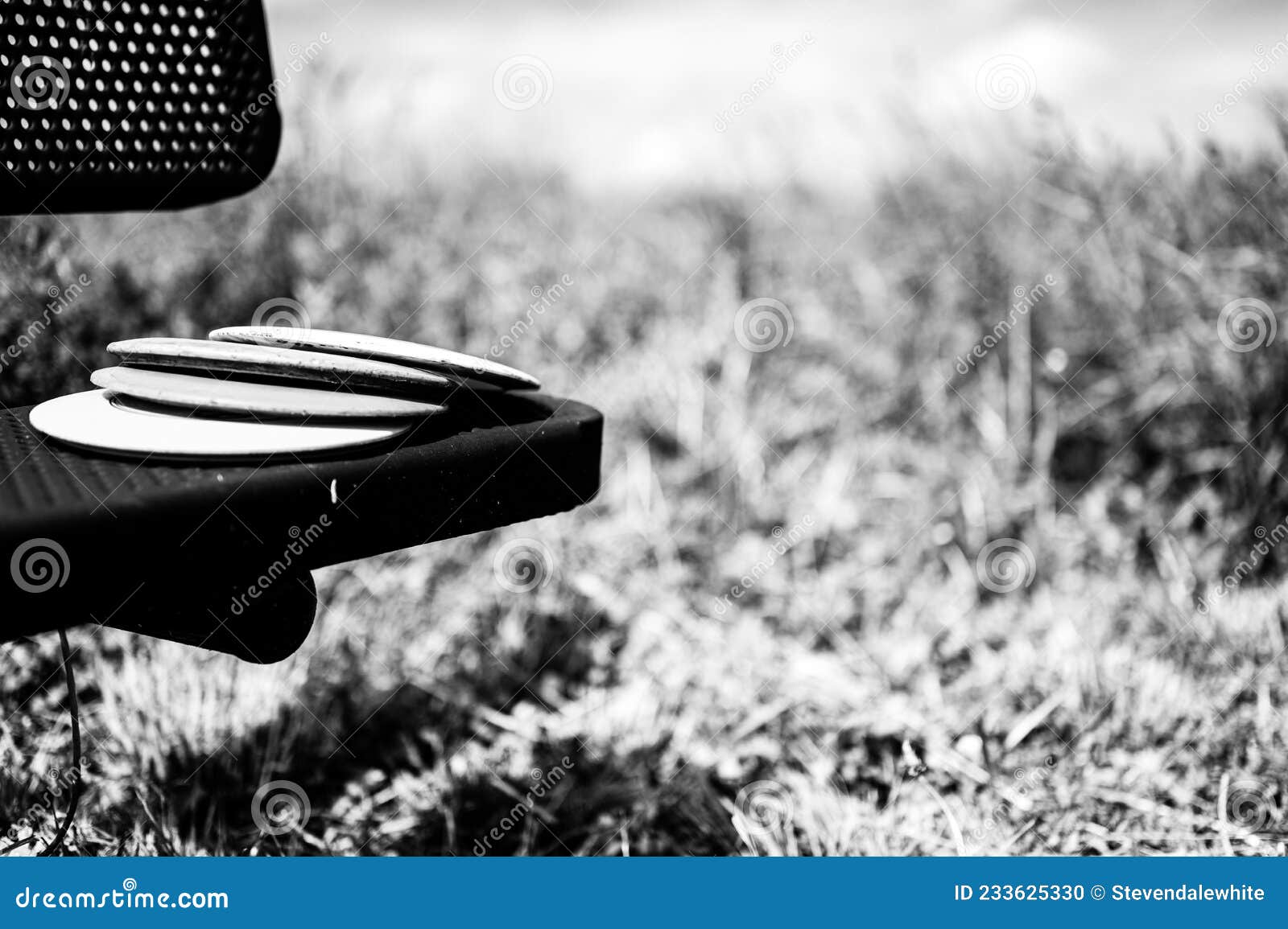 Pile of Discs Resting on a Bench in the Golf Course Park Stock Photo