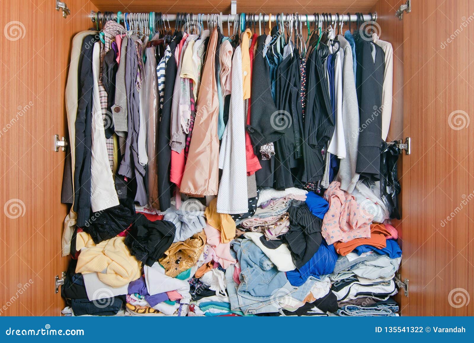 pile of messy clothes in closet. untidy cluttered woman wardrobe
