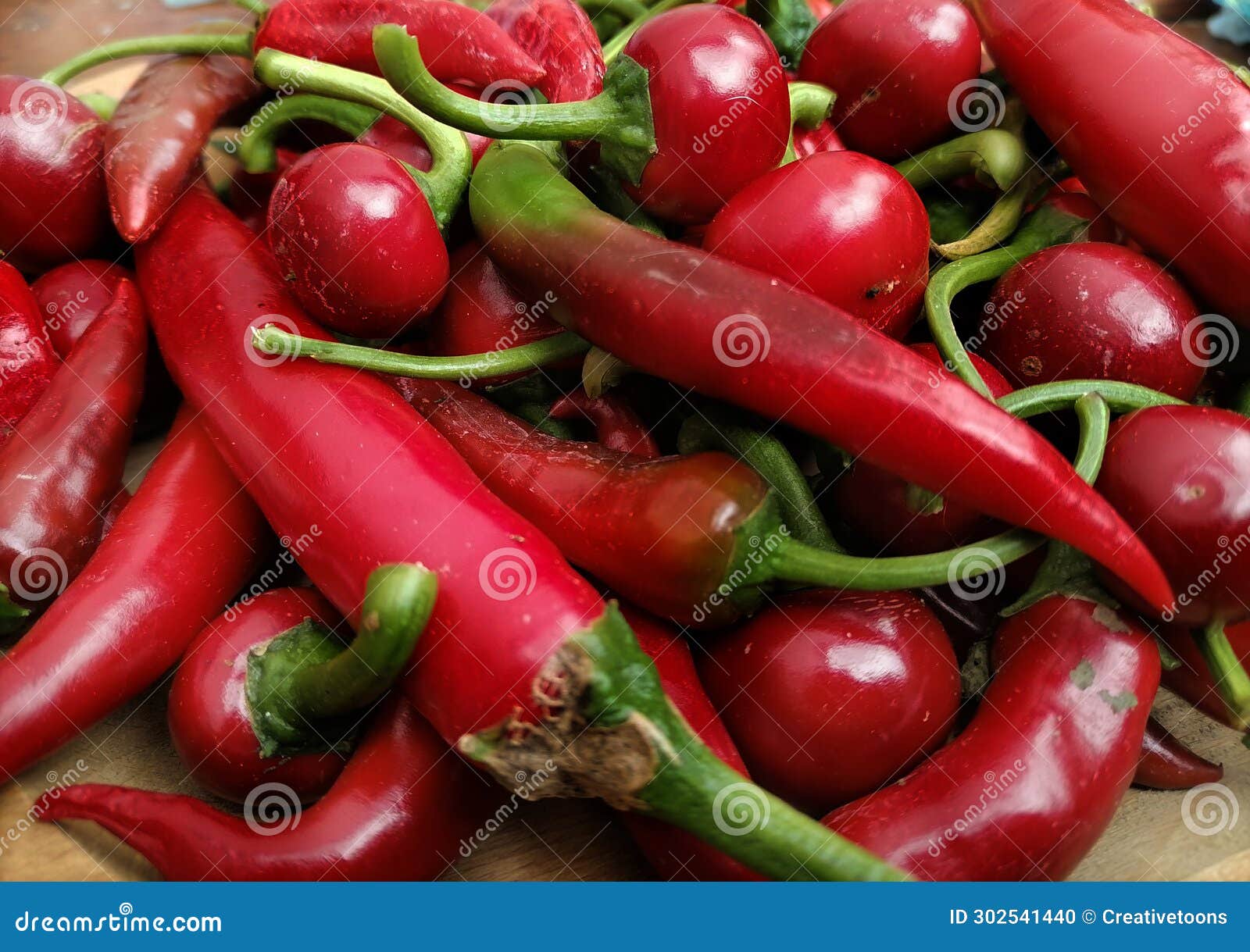 pile red hot peppers on wooden table close up. hot peppers background. cherry peppers and italian long hots