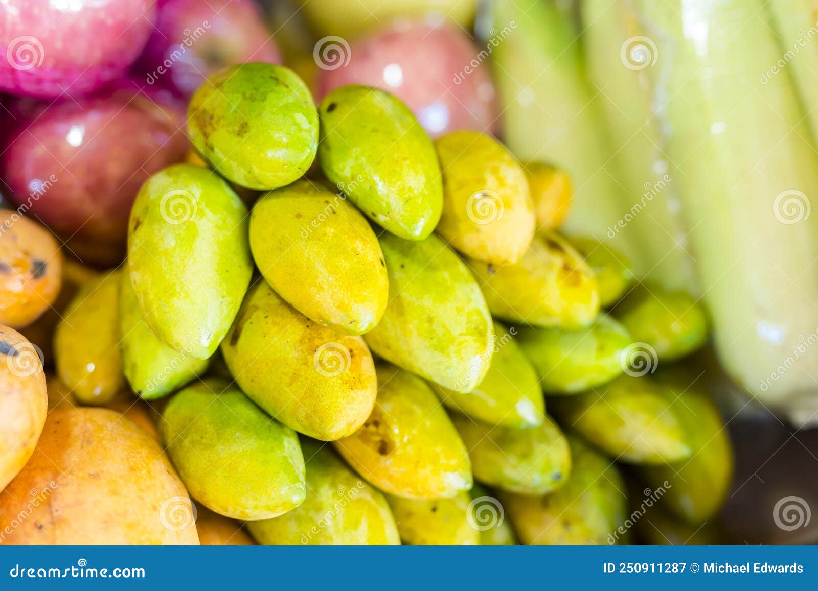 a pile of unripe pahutan mangoes for sale at a public market in tagaytay, philippines