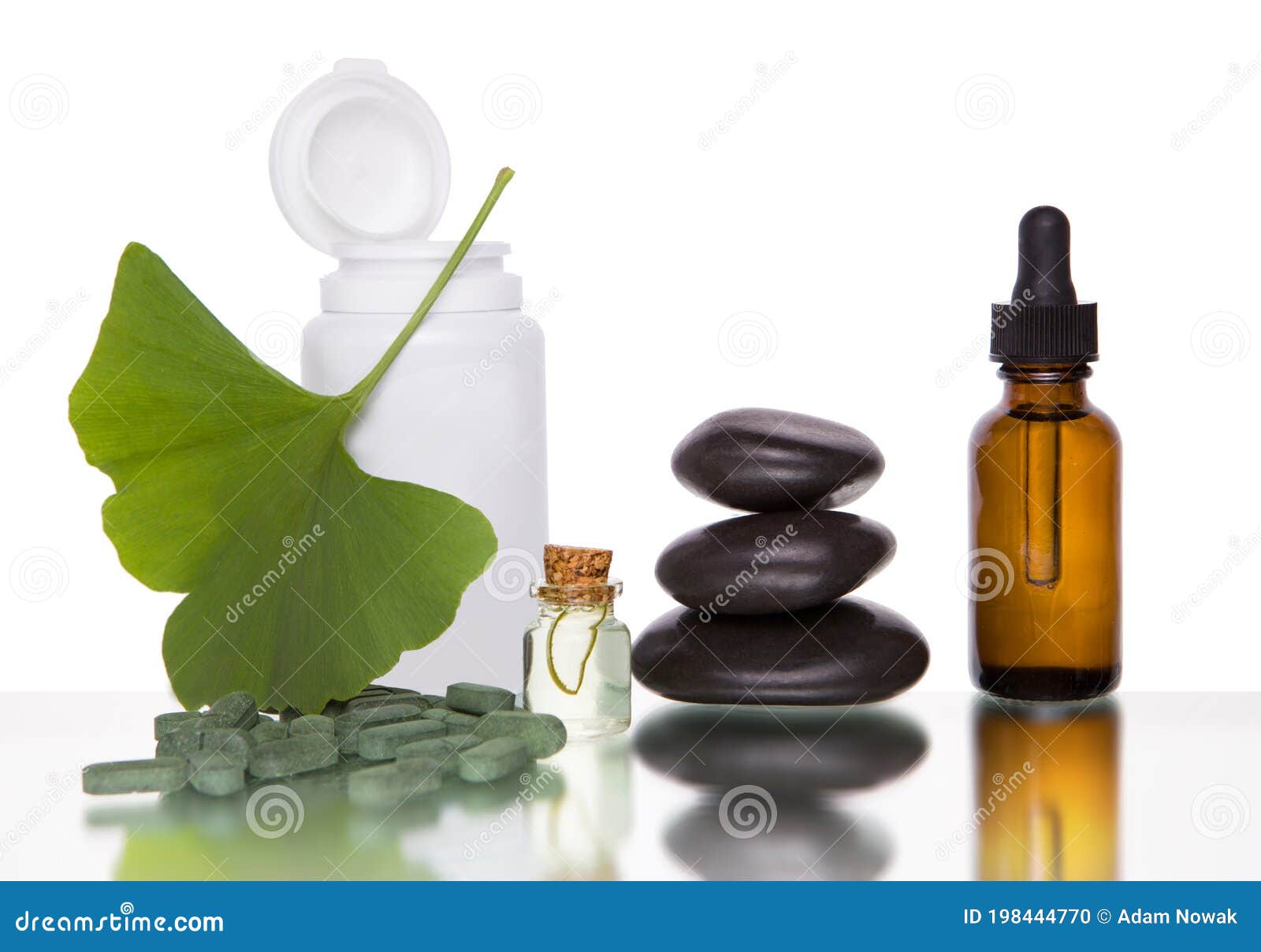 pills with extract from the ginkgo in bottle and green leaves  on a white background