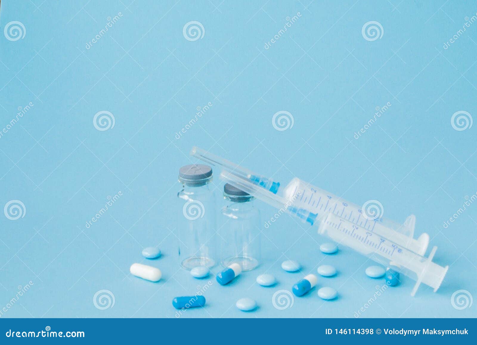 Pills and Medical Injection on Blue Background. Creative Idea for