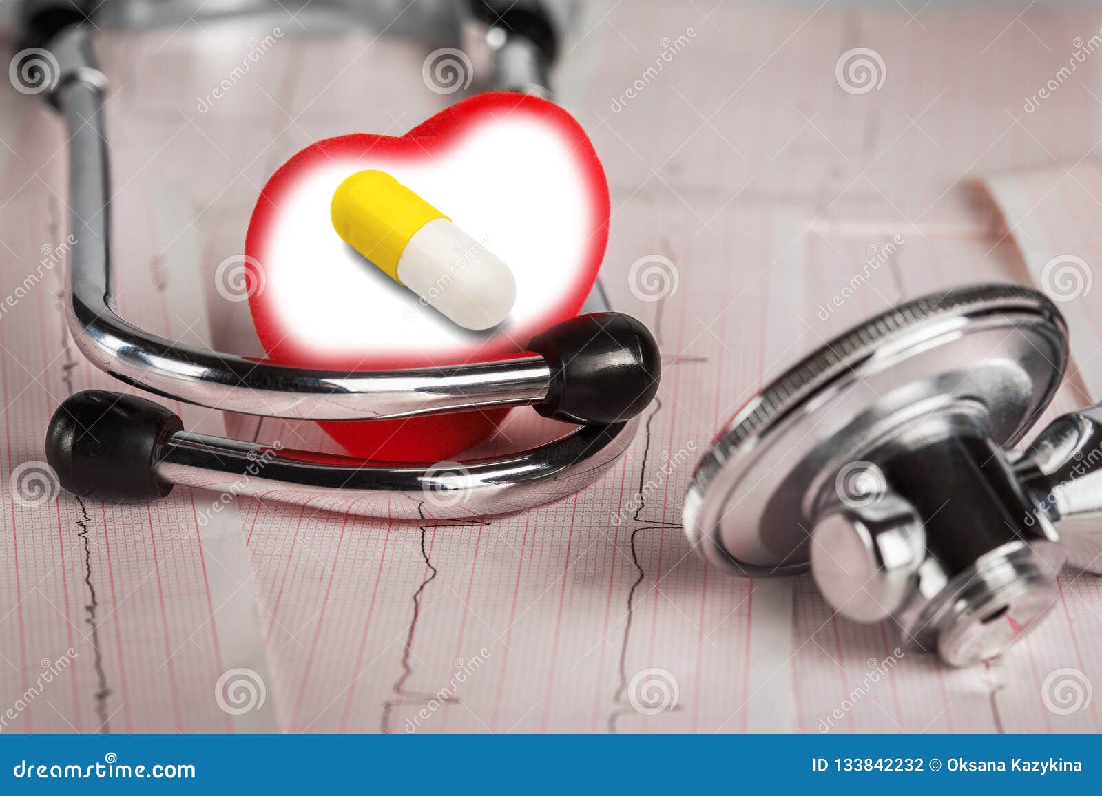 Pills and medical stethoscope with cardiogram.Conceptual medicine.Treatment on time