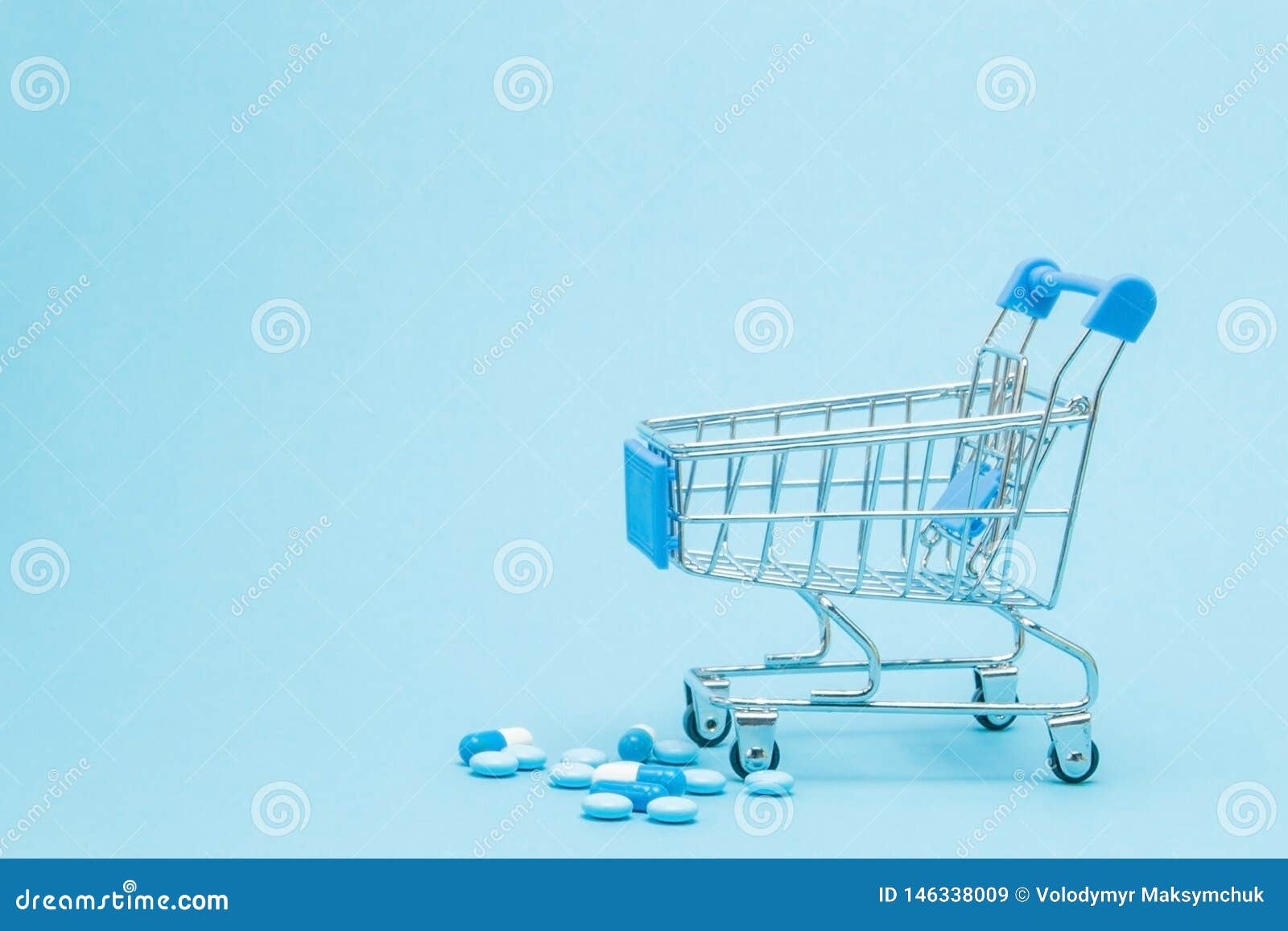 Pills and Shopping Trolley on Blue Background. Creative Idea for Health