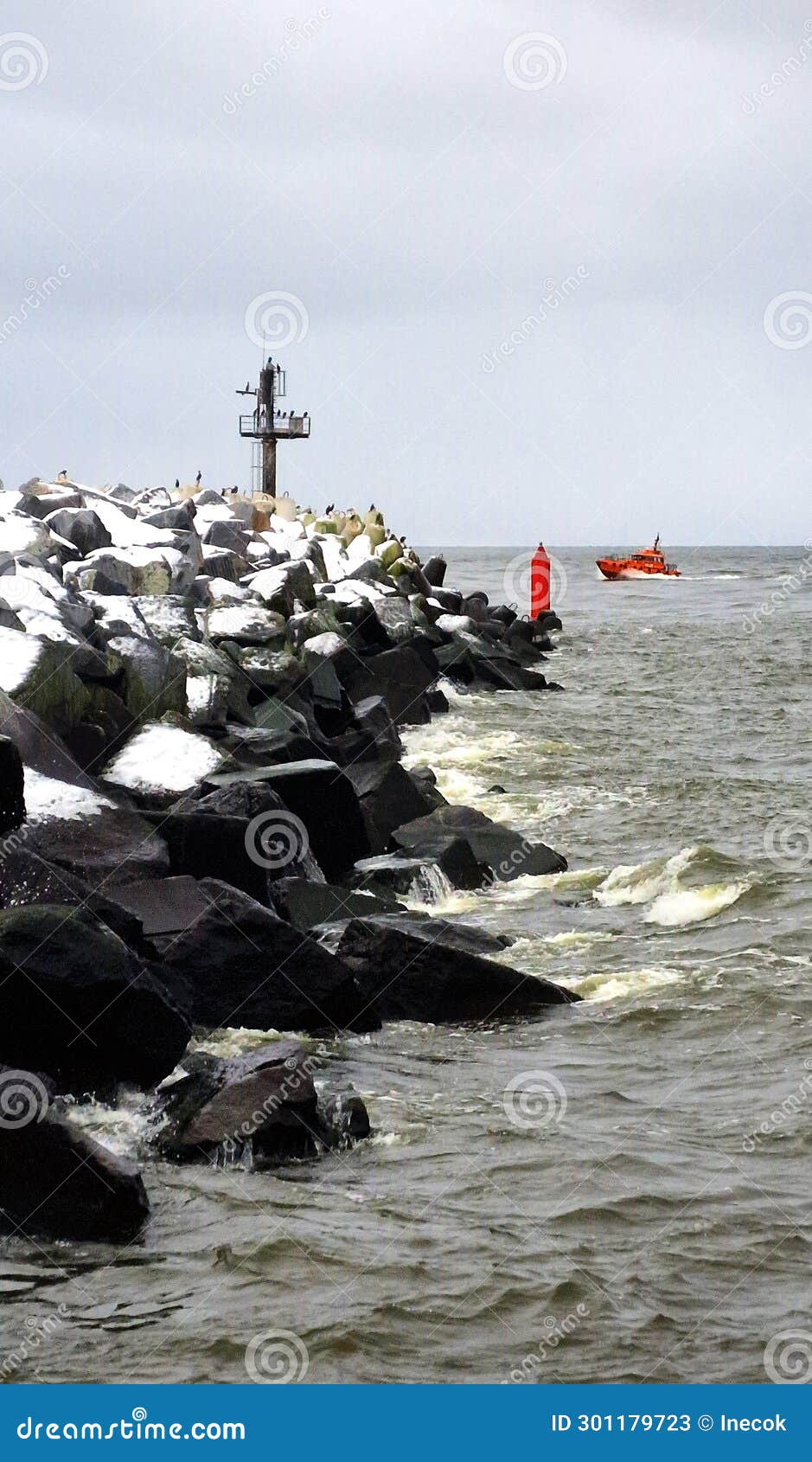 the pilot's small red boat returns through the port gates.