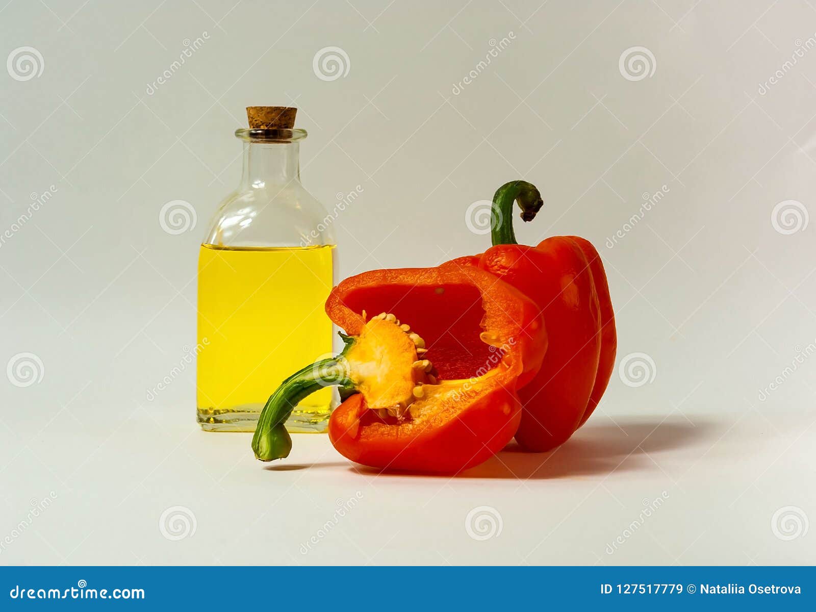 Pimienta y aceite de oliva frescos anaranjados en la botella de cristal en el fondo blanco El concepto de comida sabrosa y sana, espacio de la copia, primer