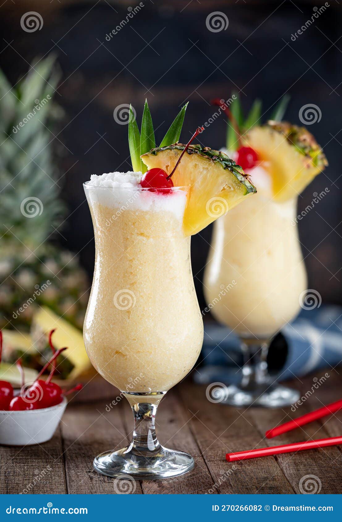 pina colada cocktail with cherry, pineapple and leaves