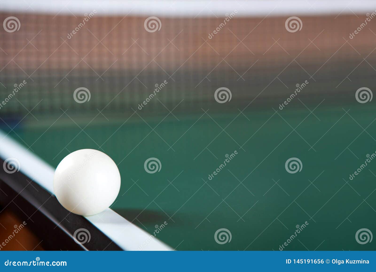 A Ping Pong Ball on the Edge of a Green Ping Pong Table Stock Photo