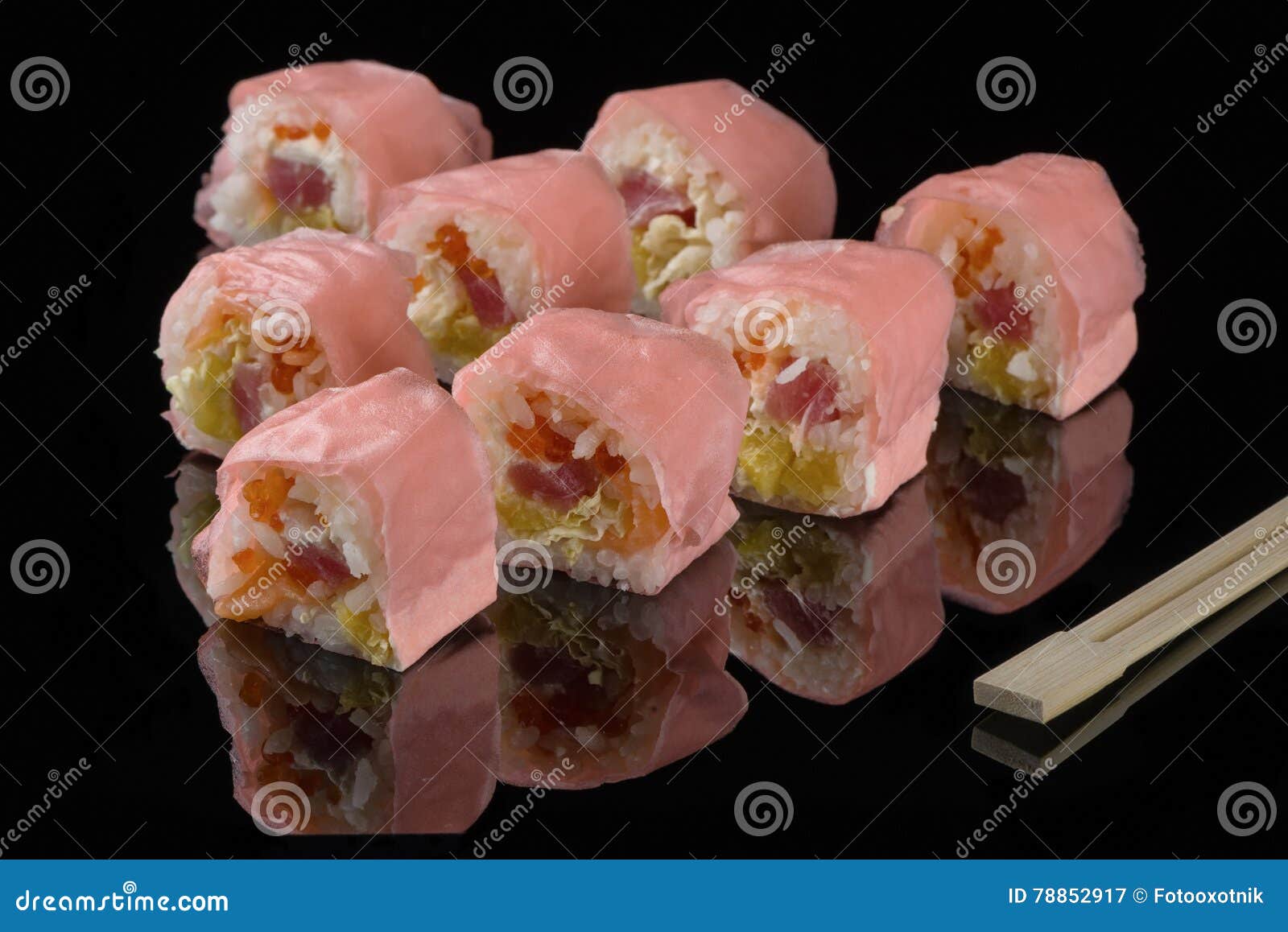 pink beaters and wooden sticks for sushi on black acryle