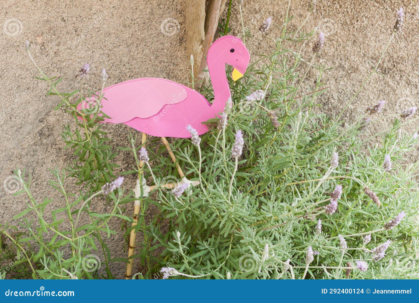 pink flamingo sitting in a plant of lavander on 