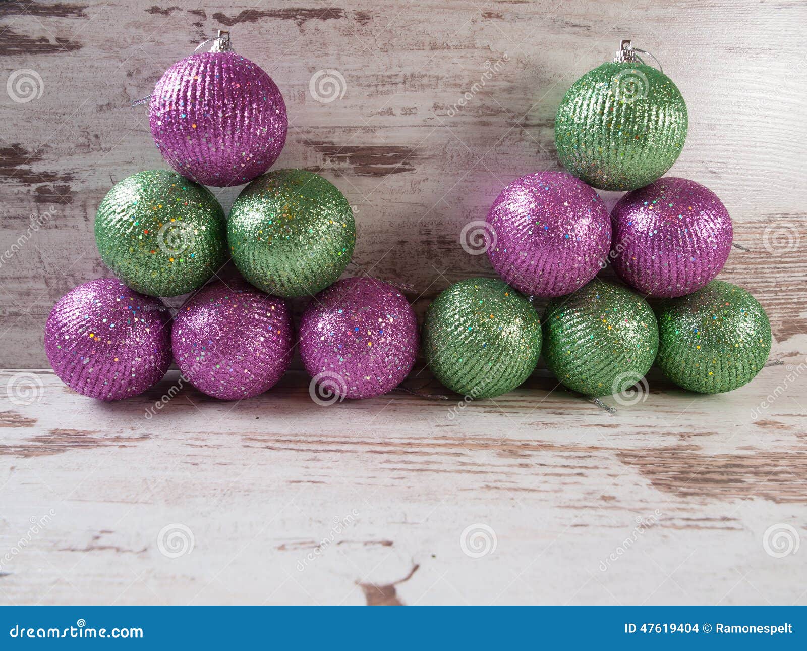 Pink and Green Christmas Balls in a Stack Over Wooden Background Stock