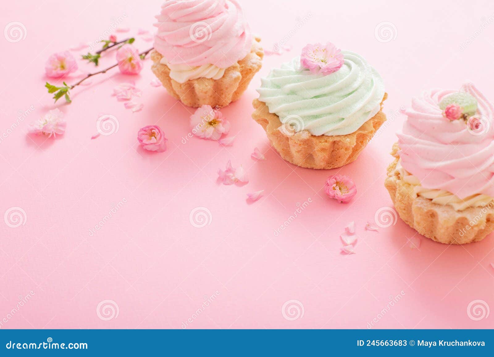 Pink and Green Cupcakes with Spring Flowers on Pink Background Stock