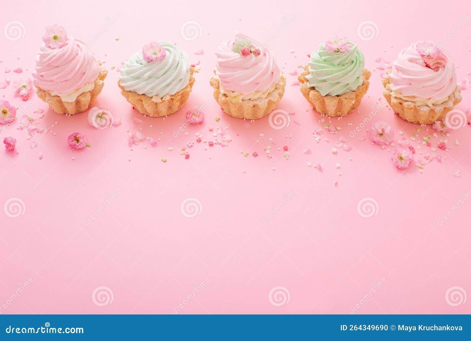 Pink and Green Cupcakes with Spring Flowers on Pink Background Stock