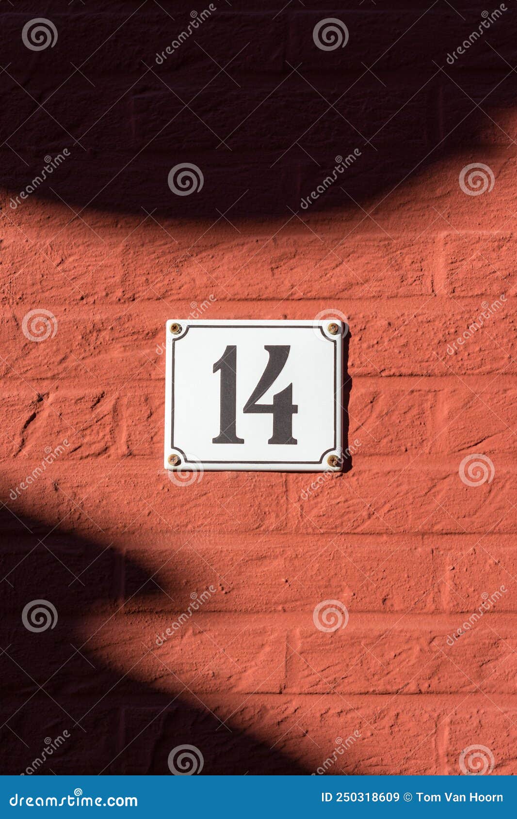 white house number plate 14 on red wall