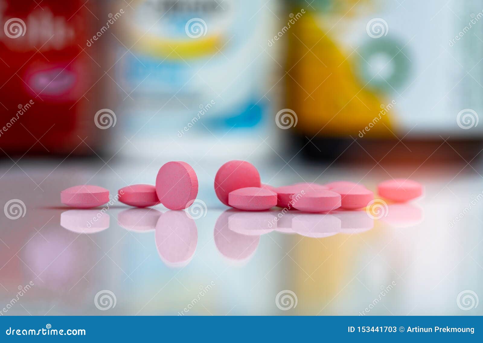 pink tablets pills on blurred background of drug box and drug bottle. vitamins and supplements tablets. pharmacy drugstore.