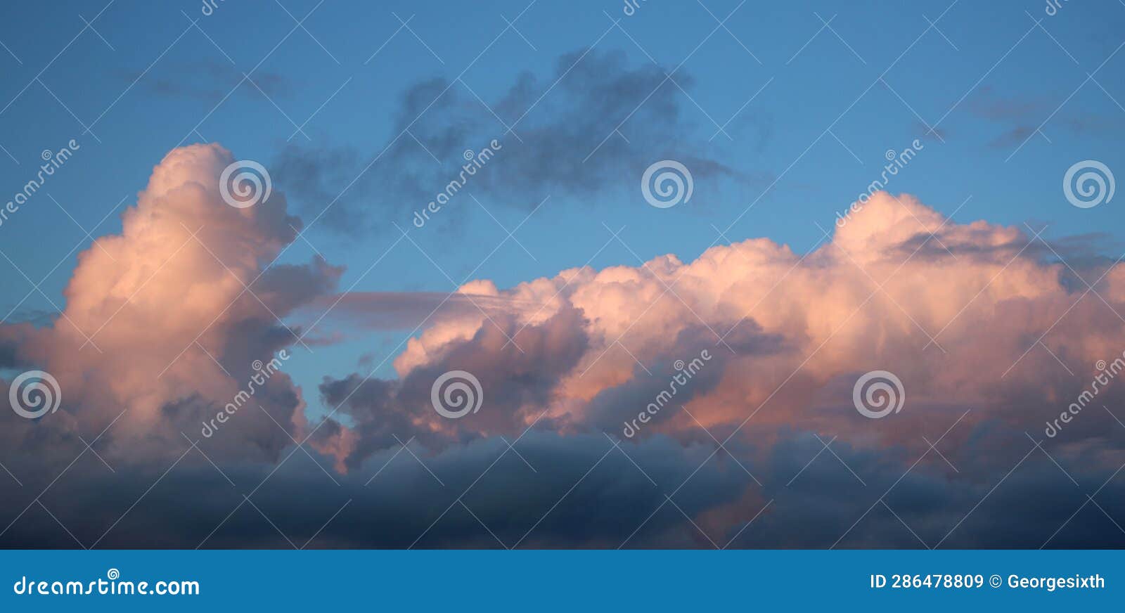 pink tinged cumulo-nimbus clouds at sunset