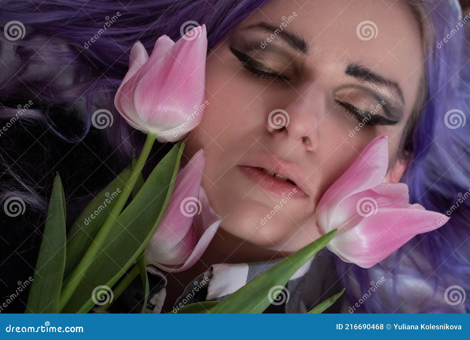 pink tulips on the background of a woman`s face