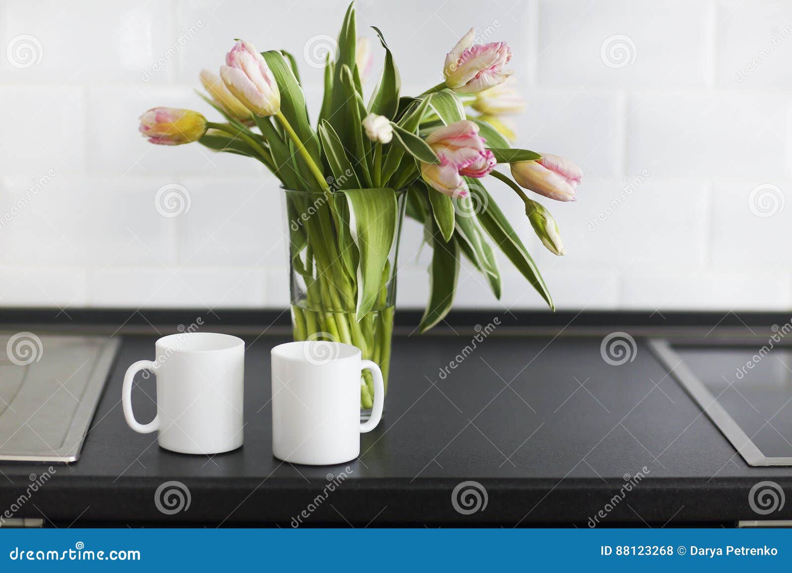 pink tulips bouquet in glass vase on the kitchen