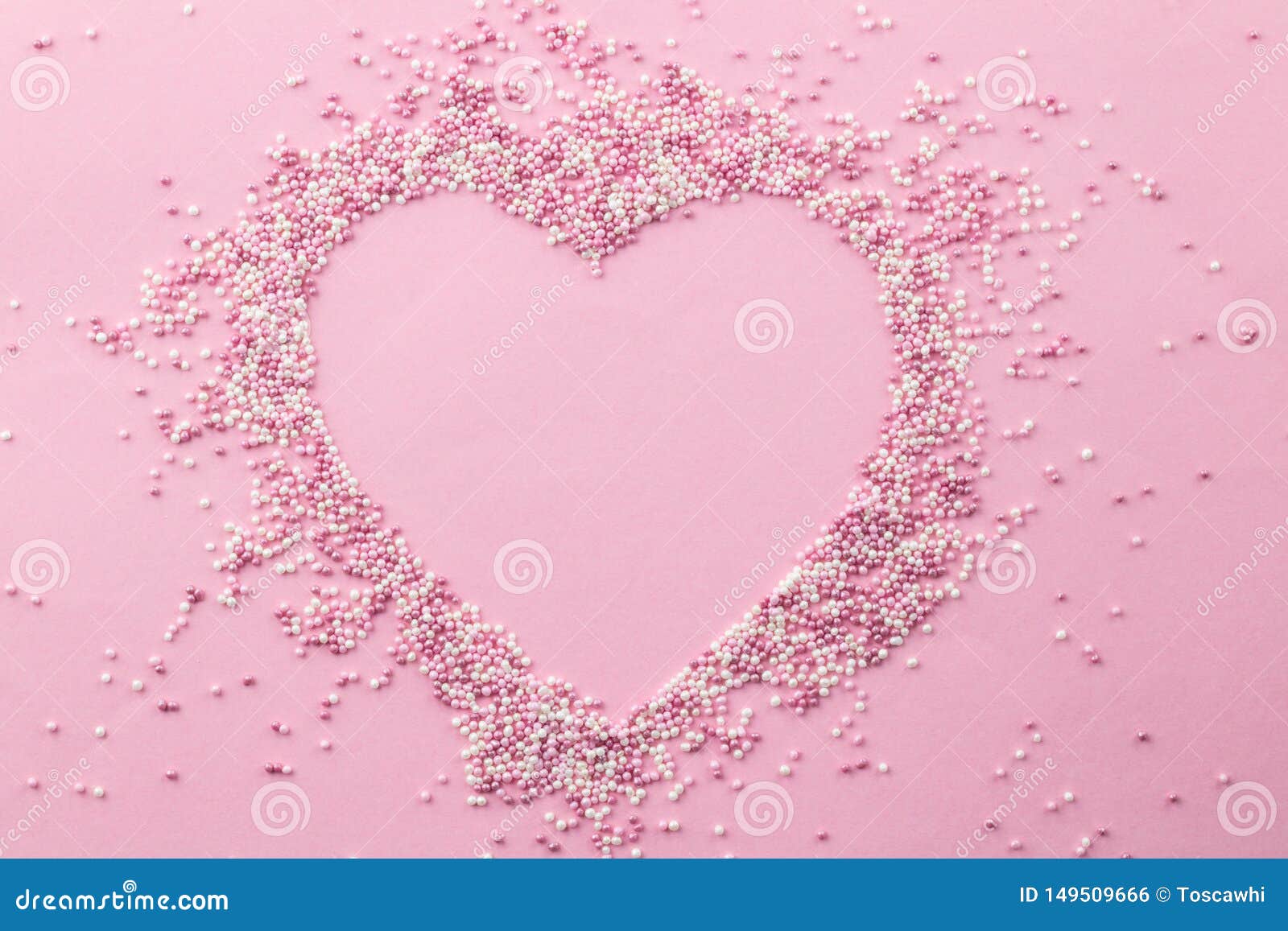 pink and white pearly cake sprinkles d in a heart  with empty space for text in the centre - sprinkles on pink