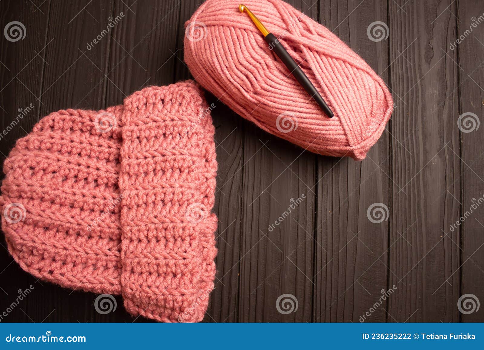 Pink Yarn and Warm Crochet Yarn Hat for Crocheting on a Dark Table
