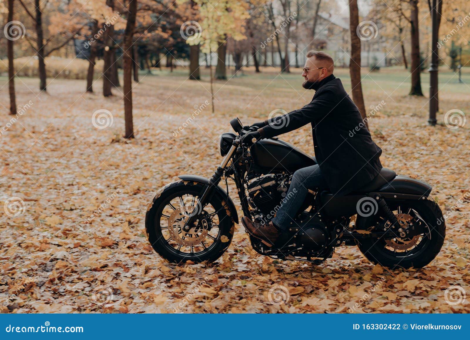 Lateral De Motocicleta De Hombre De Confianza, Tiene Aventura En Dos Ruedas En El Parque De Otoño, Usa Ropa El Foto de archivo - Imagen hombre, tiro: