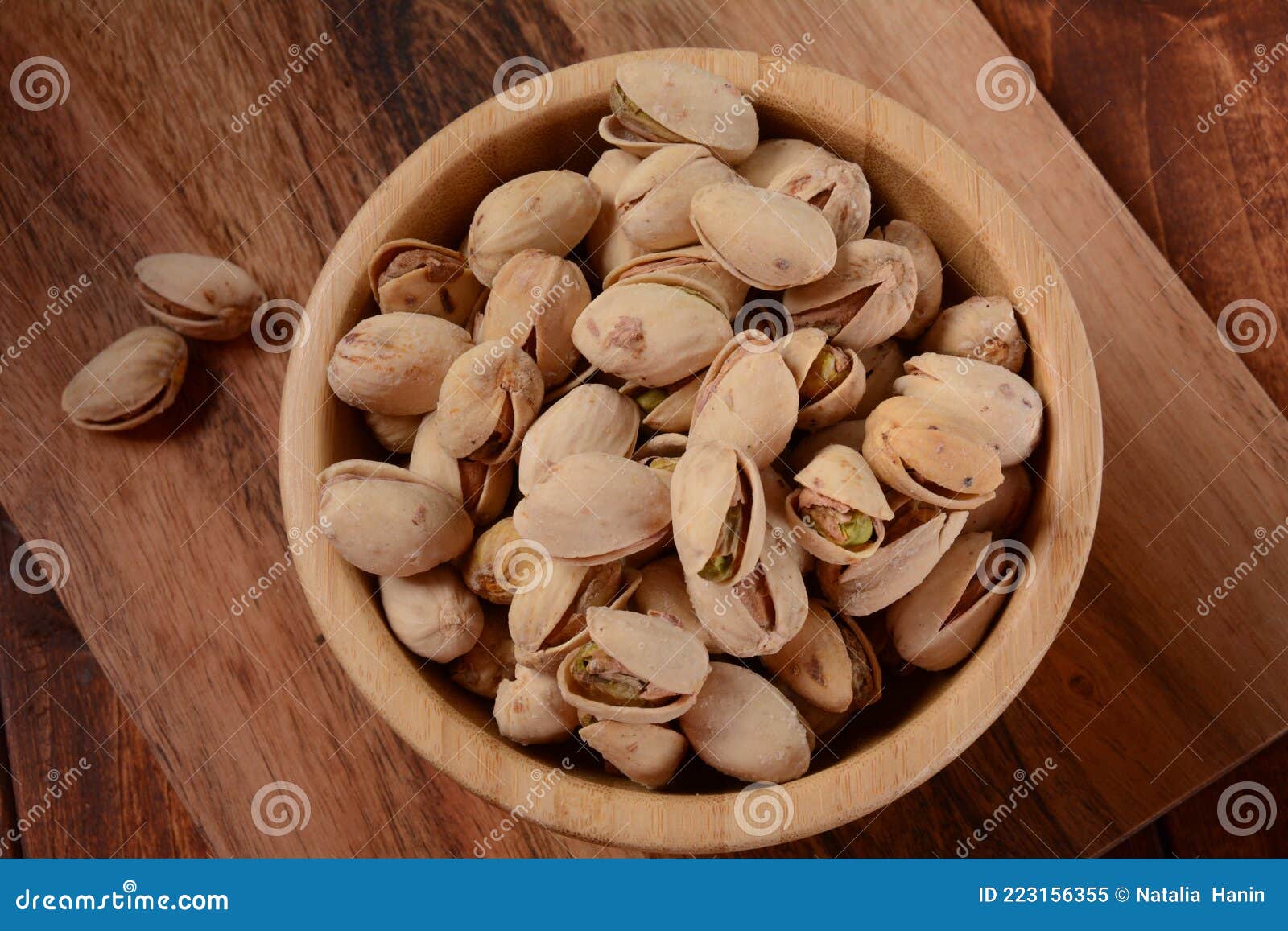 Pistachios in a Wooden Bowl on Wooden Surface, Pile of Pistachios Stock