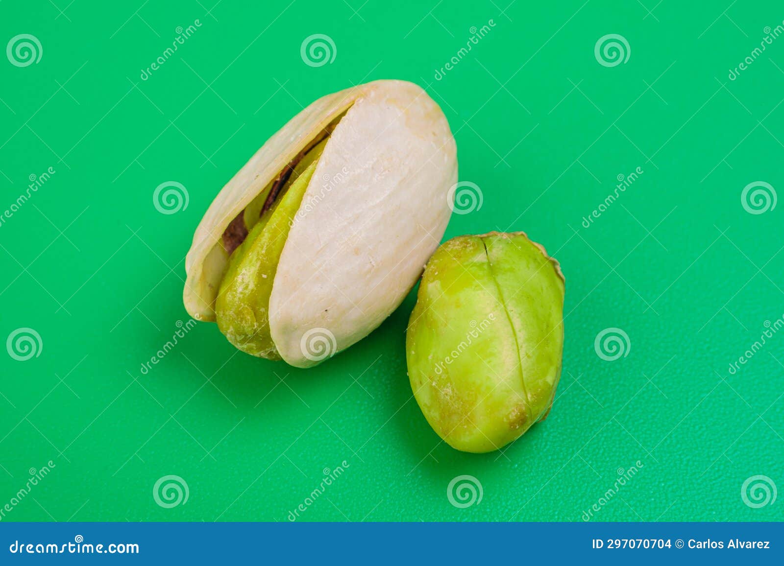 pistacho abierto con otro fruto al lado sobre fondo verde