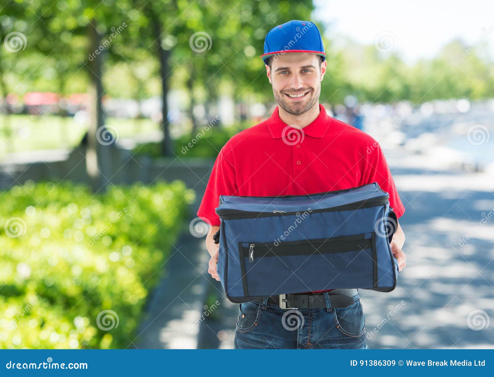 Pizza Deliveryman with Blue Hat and Delivery Bag in the Park Stock