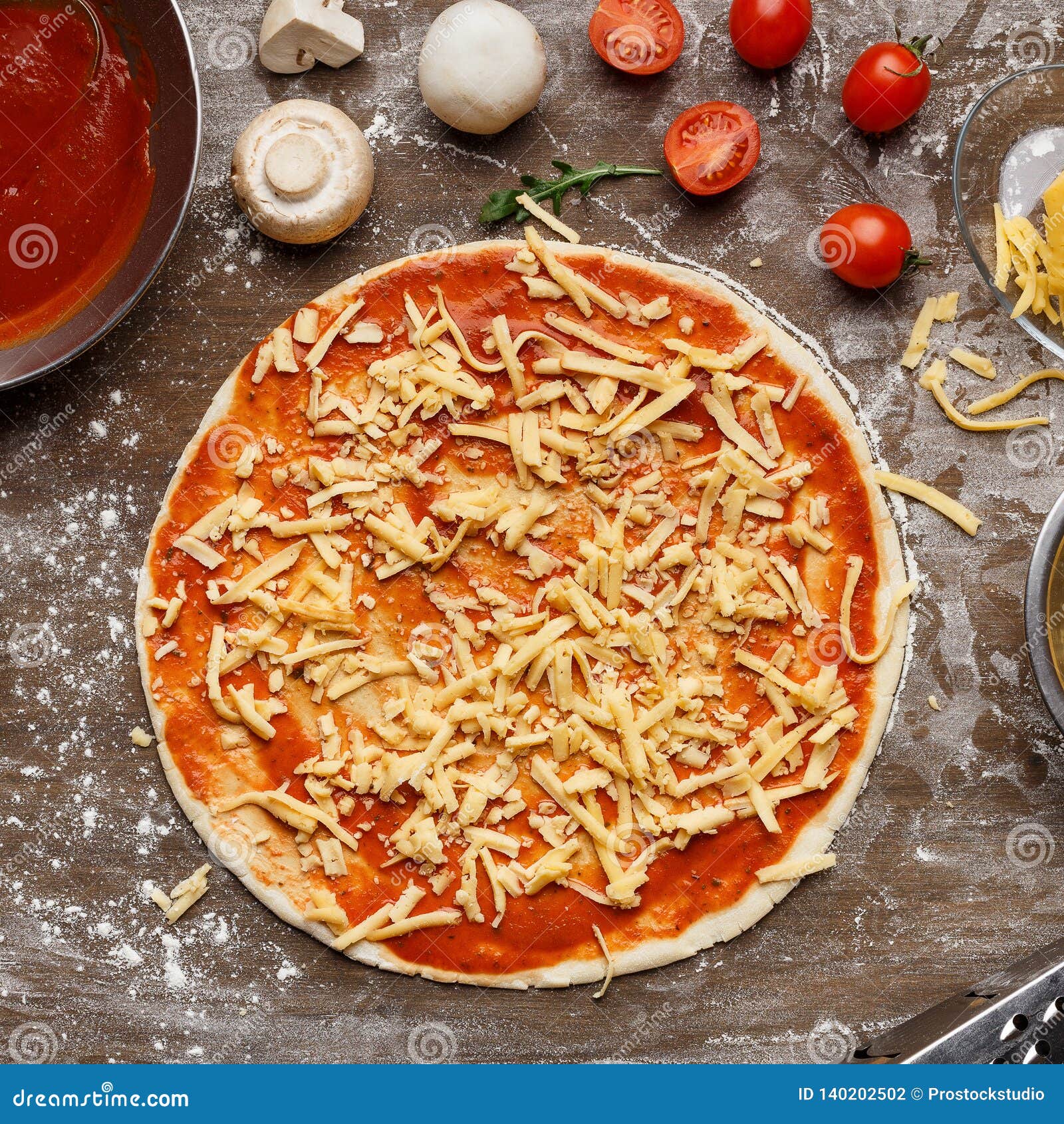 Pizza Preparation, Grated Cheese and Ingredients Around Stock Photo