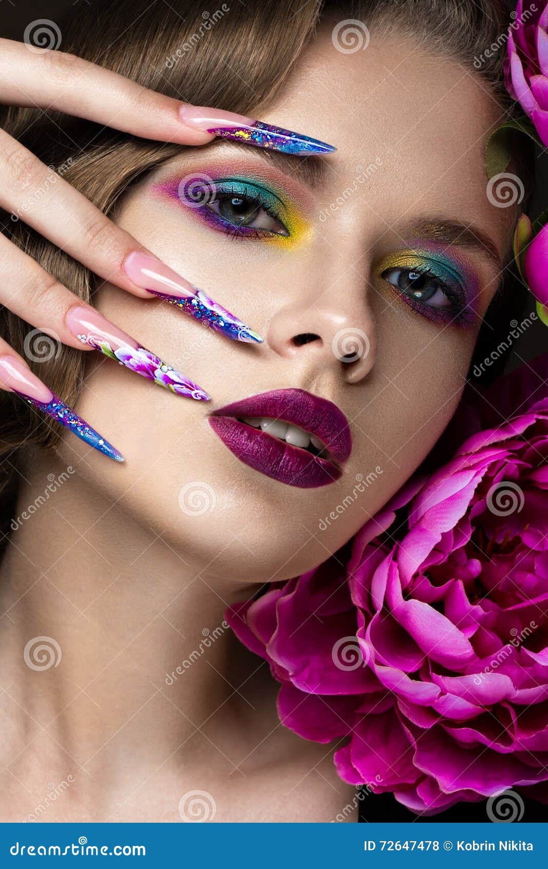 Piękna dziewczyna z kolorowym makijażem, kwiatami, retro fryzurą i gwoździami, długo Manicure'u projekt Piękno twarz